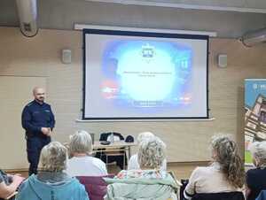 Na zdjęciu widać policjanta i uczestników warsztatów.