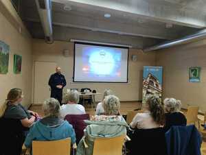 Na zdjęciu widać policjanta i uczestników warsztatów.