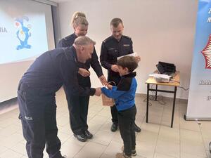 Na zdjęciu widać przebieg zajęć profilaktycznych w komendzie, w tym Policjantów, uczniów, przedszkolaków i wychowawczynie.