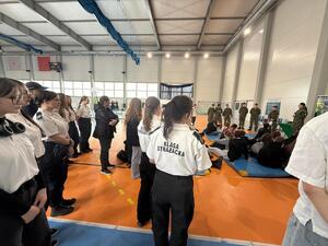 Na zdjęciu widać policjantów, funkcjonariuszkę Straży Granicznej oraz zgromadzonych uczniów.