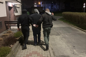 Na zdjęciu widać zatrzymanego prowadzonego przez policjantów.