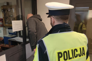 Na zdjęciu widać policjanta oraz osobę poddawaną badaniu na zawartość alkoholu w organizmie.