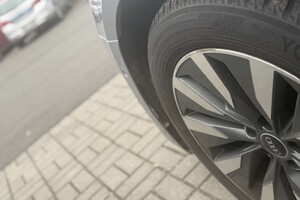 Na zdjęciu widać koło samochodu z logiem Audi, a w tle radiowóz.