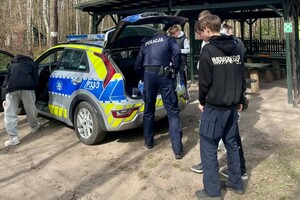 Na zdjęciu widać policjantów i uczniów w trakcie wspólnych zajęć profilaktycznych w terenie.
