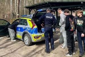 Na zdjęciu widać policjantów i uczniów w trakcie wspólnych zajęć profilaktycznych w terenie.