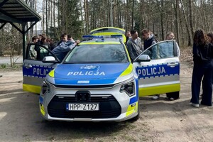 Na zdjęciu widać policjantów i uczniów w trakcie wspólnych zajęć profilaktycznych w terenie.