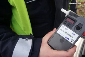 Na zdjęciu widać policjanta z alkomatem w dłoni.