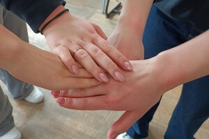 Na zdjęciu widać złączone dłonie.