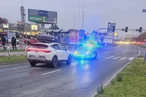 Na zdjęciu widać policyjny radiowóz, skrzyżowanie oraz jasny samochód.