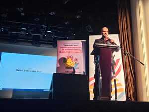 Na zdjęciu widać policjanta na scenie, podczas prelekcji.