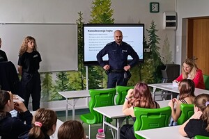 Na zdjęciu widać policjanta, uczennice klasy policyjnej oraz uczniów podczas zajęć.