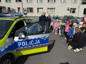 Na zdjęciu widać policjanta oraz przedszkolaki.