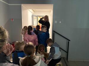Na zdjęciu widać policjanta oraz przedszkolaki.