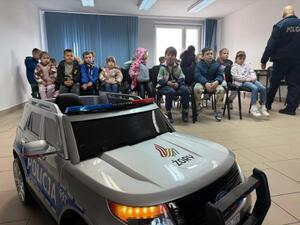 Na zdjęciu widać policjanta oraz przedszkolaki.