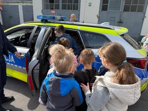 Na zdjęciu widać policjanta oraz przedszkolaki.