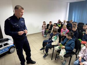 Na zdjęciu widać policjanta oraz przedszkolaki.