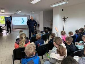 Na zdjęciu widać policjanta oraz przedszkolaki.