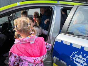 Na zdjęciu widać policjanta oraz przedszkolaki.