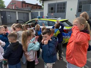 Na zdjęciu widać policjanta oraz przedszkolaki.