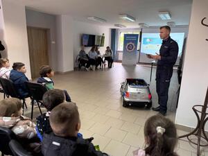 Na zdjęciu widać policjanta oraz przedszkolaki.