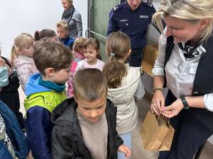 Na zdjęciu widać policjanta oraz przedszkolaki.