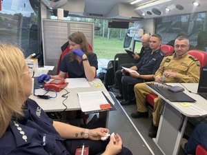 Na zdjęciu widać policjantów, strażaków oraz inne osoby podczas akcji krwiodawstwa.