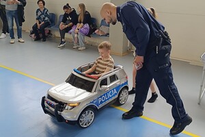 Na zdjęciu widać policjanta, dzieci i innych uczestników festynu.