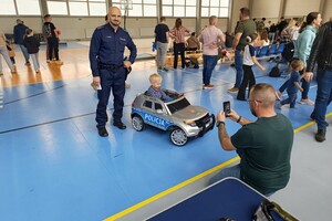 Na zdjęciu widać policjanta, dzieci i innych uczestników festynu.