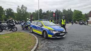 Na zdjęciu widać radiowóz, policjantów i motocyklistów.