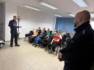 Na zdjęciu widać policjantów oraz uczniów podczas odwiedzin w żorskiej komendzie Policji.