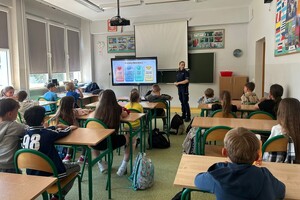 Na zdjęciu widać policjantkę oraz uczniów w trakcie wspólnych zajęć.