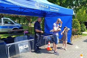 Na zdjęciu widać policjanta i uczestników festynu.