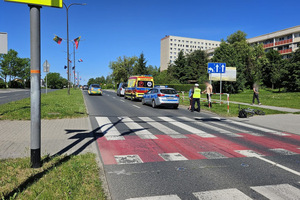 Na zdjęciu widać radiowóz, karetkę pogotowia oraz samochody i rejon przejazdu dla rowerzystów.