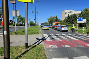 Na zdjęciu widać radiowóz, karetkę pogotowia oraz samochody i rejon przejazdu dla rowerzystów.