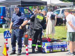 Na zdjęciu widać policjanta oraz uczestników, w tym dzieci w Parku Cegielnia.