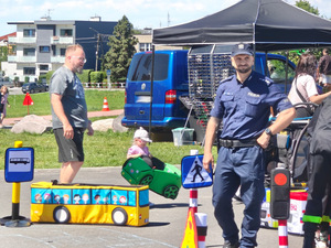 Na zdjęciu widać policjanta oraz uczestników, w tym dzieci w Parku Cegielnia.