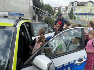 Na zdjęciu widać policjanta i uczniów.