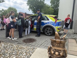 Na zdjęciu widać policjanta i uczniów.