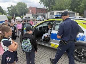 Na zdjęciu widać policjanta i uczniów.