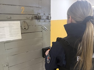 Na zdjęciu widać policjantkę zamykającą drzwi do celi.