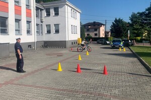 Na zdjęciu widać policjanta oraz uczniów, podczas egzaminu na kartę rowerową.