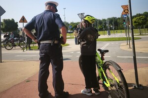 Na zdjęciu widać policjanta oraz uczniów, podczas egzaminu na kartę rowerową.