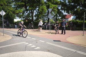 Na zdjęciu widać policjanta oraz uczniów, podczas egzaminu na kartę rowerową.