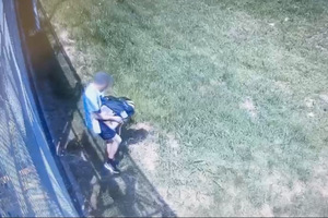 Na zdjęciu widać mężczyznę, który niesie coś w rękach.