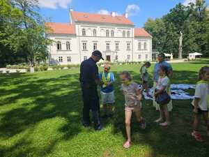 Na zdjęciu widać policjanta i uczestników półkolonii.
