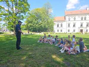 Na zdjęciu widać policjanta i uczestników półkolonii.