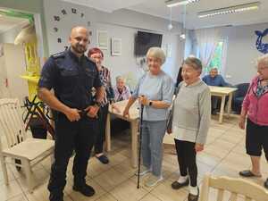 Na zdjęciu widać policjanta i seniorów podczas wspólnego spotkania.