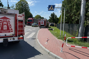 Na zdjęciu widać pojazdy służb ratowniczych, uszkodzony pojazd i okolice miejsca zdarzenia drogowego.