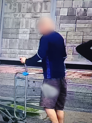 Na zdjęciu widać mężczyznę prowadzącego wózek sklepowy.