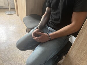 Na zdjęciu widać zatrzymanego mężczyznę w kajdankach.